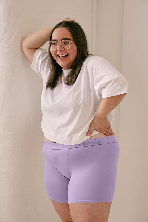 Model in glasses wearing Flissie women's bamboo boxer shorts in lavender purple with a white T-shirt