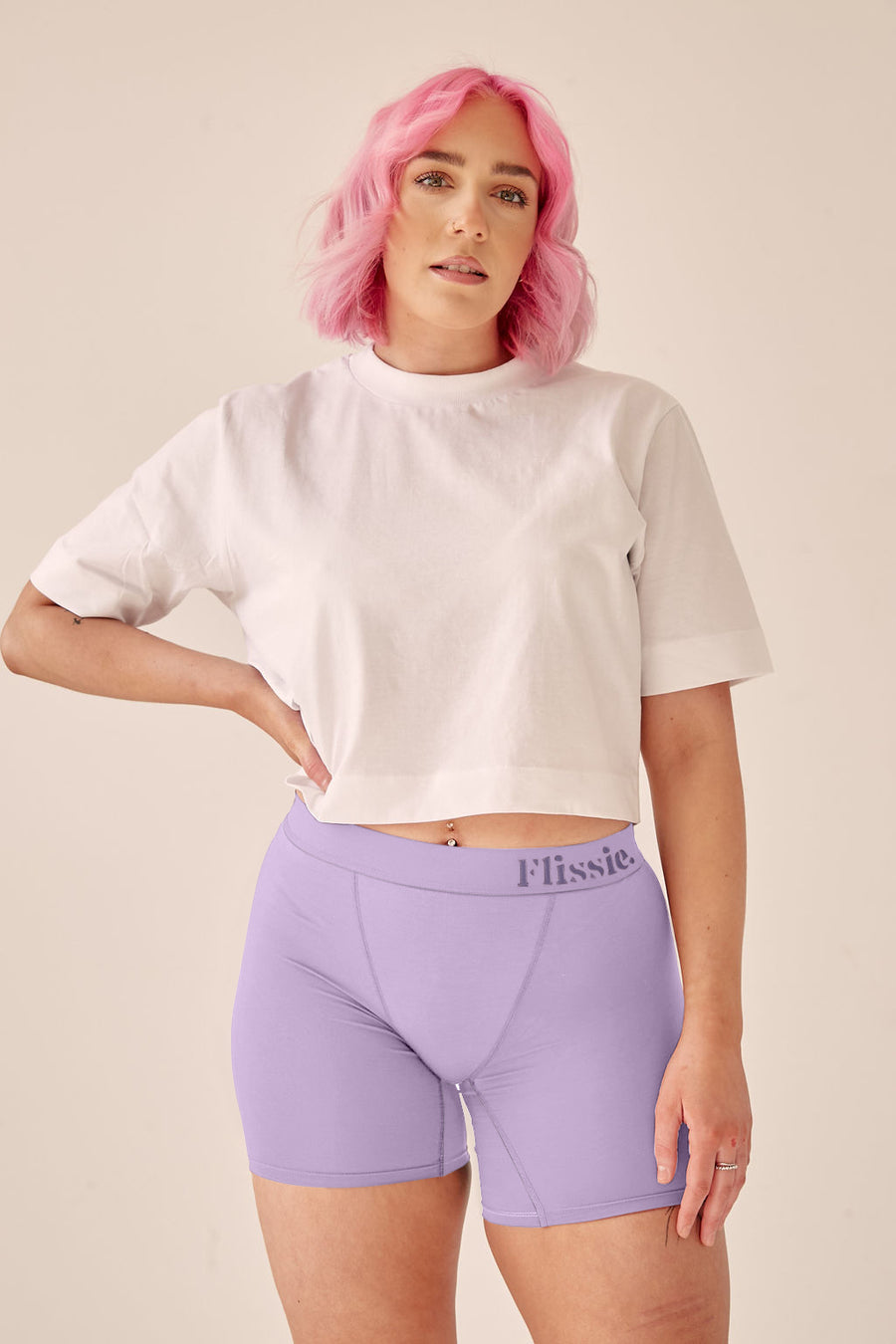 Model with pink hair wearing Flissie women's bamboo boxer shorts in lavender purple with a white T-shirt