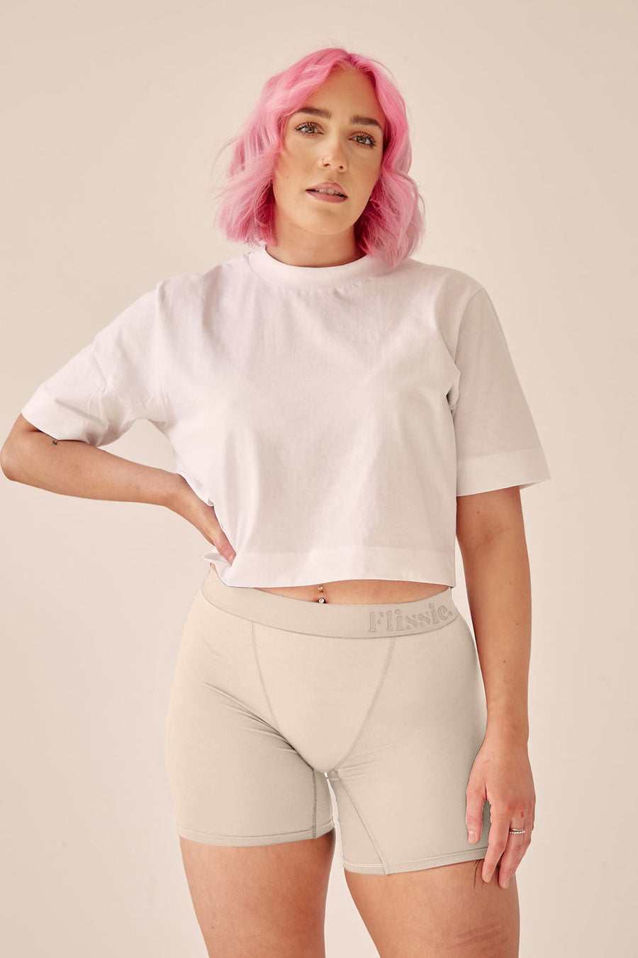 Model with pink hair wearing Flissie women's bamboo boxer shorts in taupe white with a white T-shirt