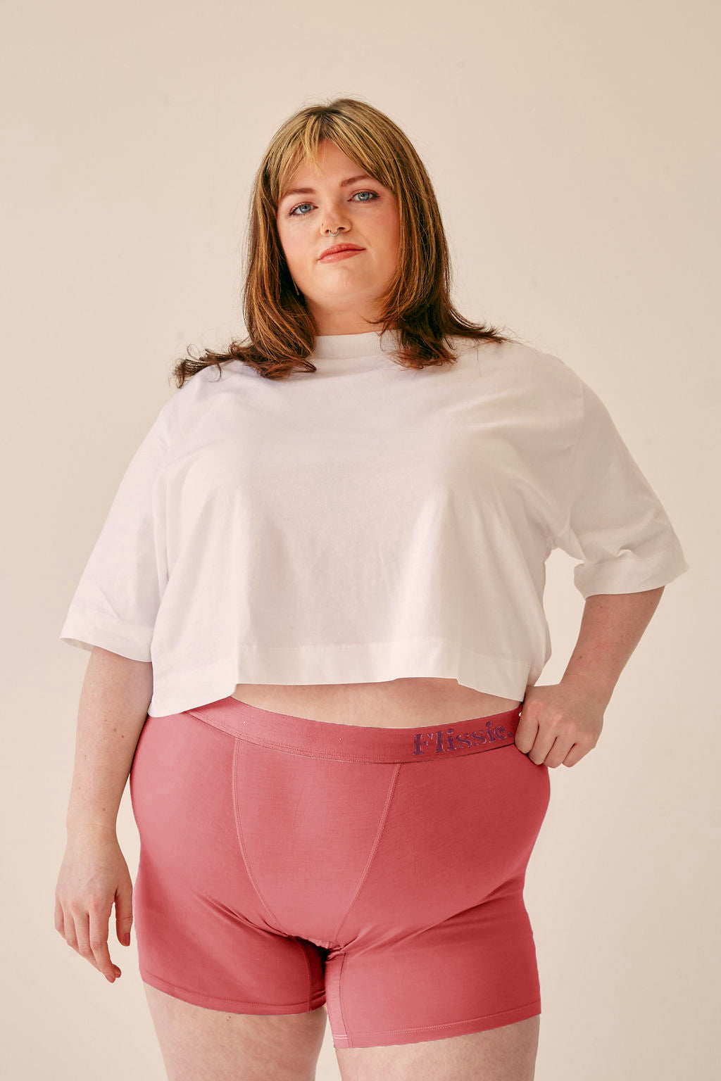 Model wearing Flissie women's bamboo boxer shorts in plum pink with a white T-shirt