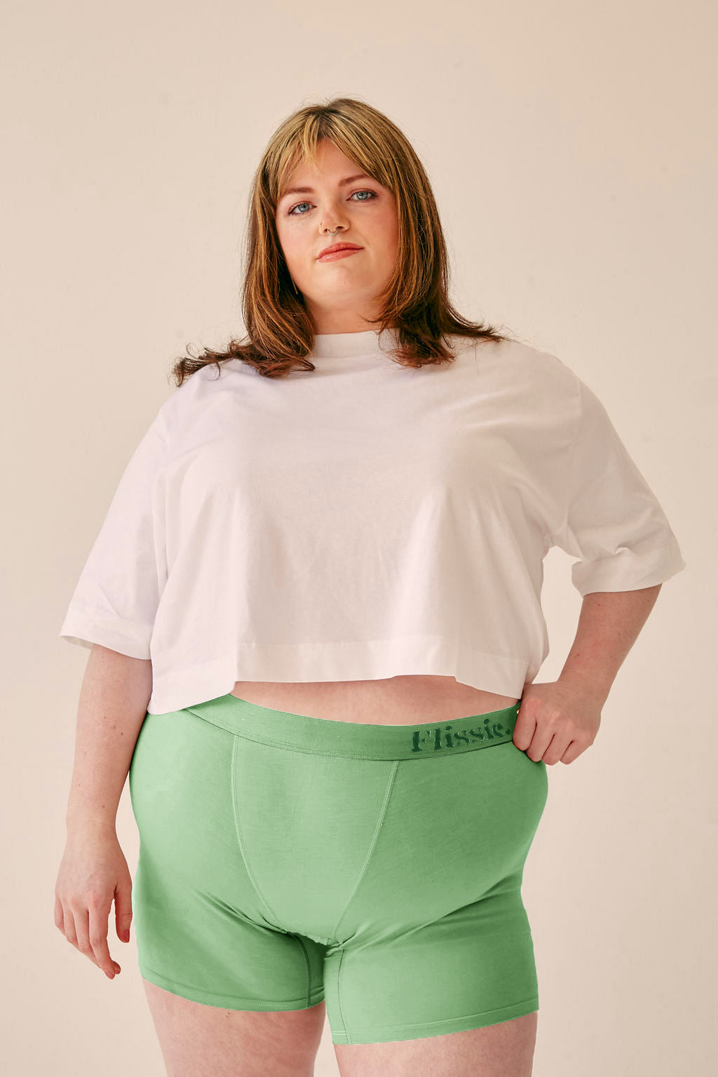 Model wearing Flissie women's bamboo boxer shorts in sage green with a white T-shirt, the 6 inch leg covering her inner thighs